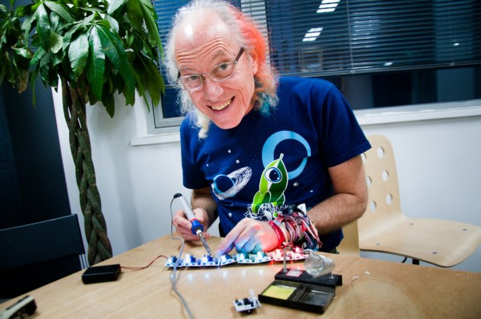 picture of mitch soldering with a space cartoon t-shirt and orange and blue hair