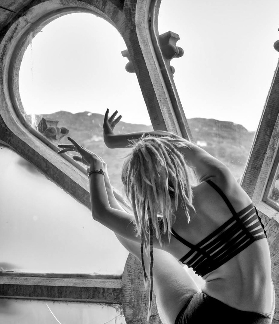 a girl doing a Yoga pose in front of the Chapel Window